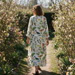 Elise spring dress back view on a garden path