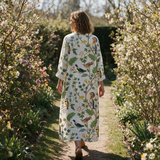 Elise spring dress back view on a garden path