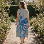 Leonie spring dress back view on a garden path